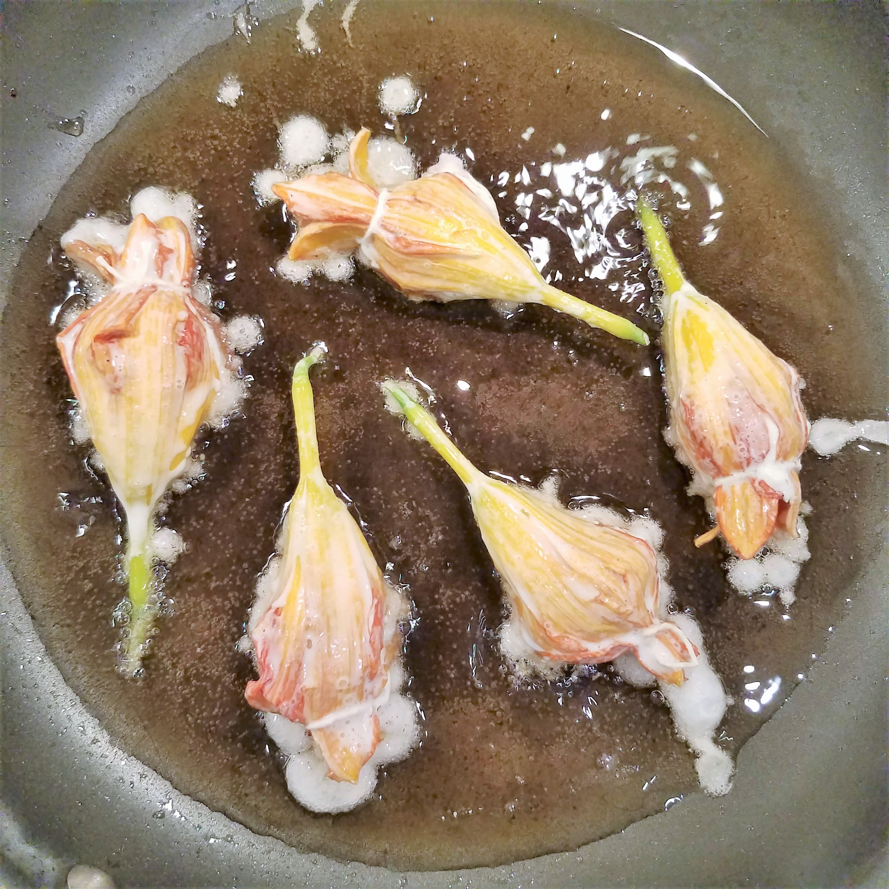 Frying the battered stuffed day lilies